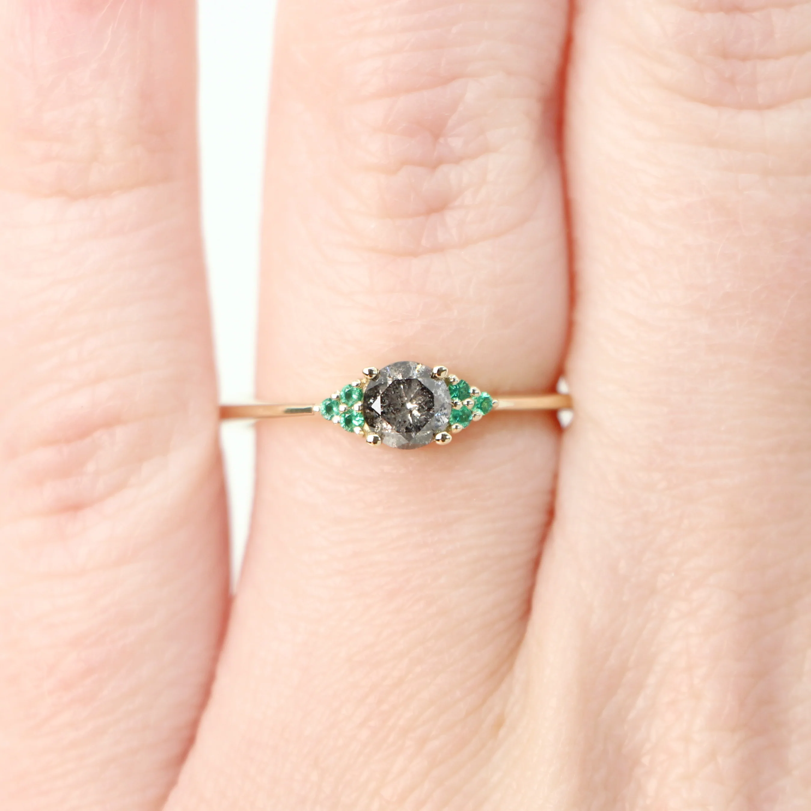 Project: Custom Imogene Ring with a 0.50 Carat Round Dark Gray Black Salt and Pepper Diamond and Emerald Accents in 14k - Image 3