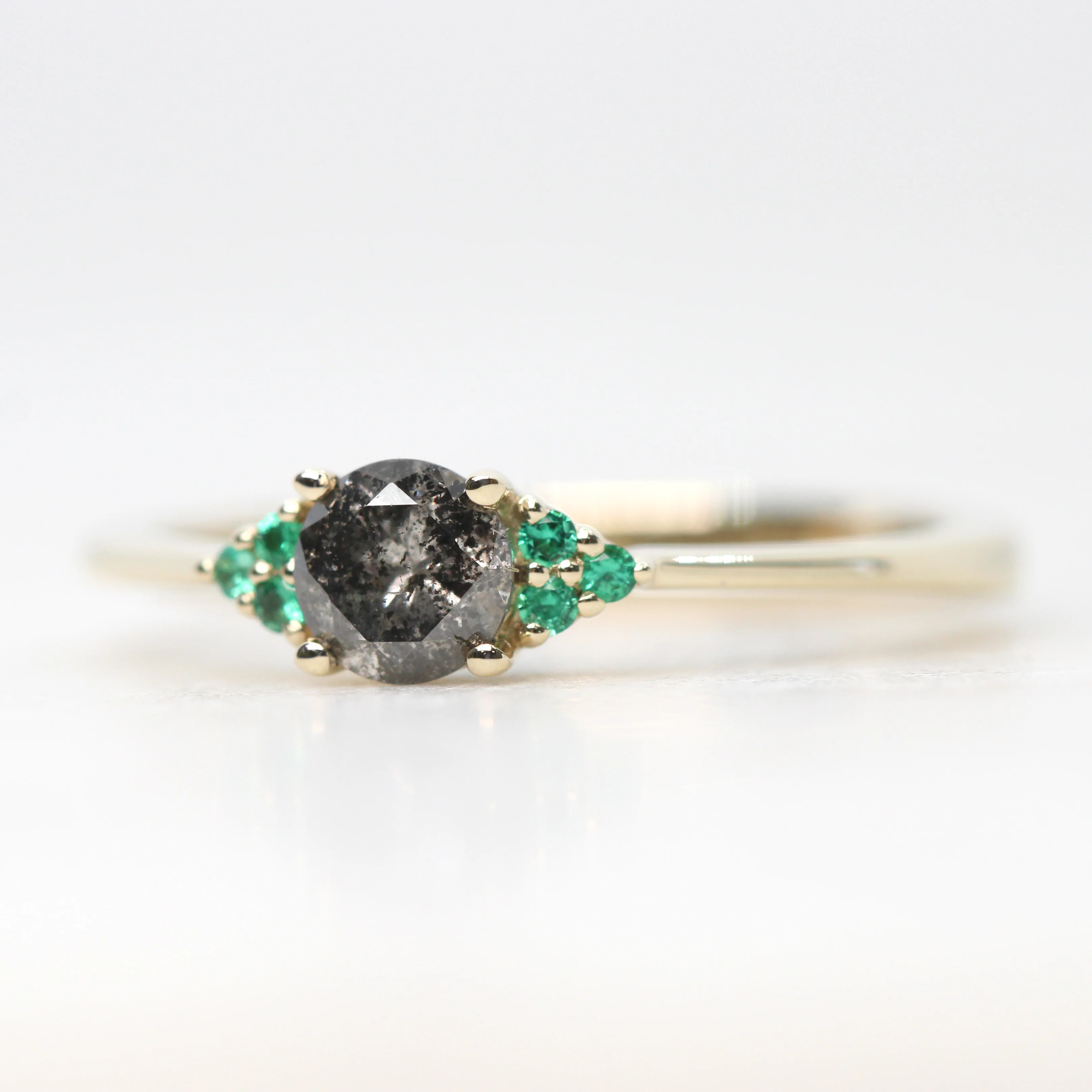 Project: Custom Imogene Ring with a 0.50 Carat Round Dark Gray Black Salt and Pepper Diamond and Emerald Accents in 14k - Image 4