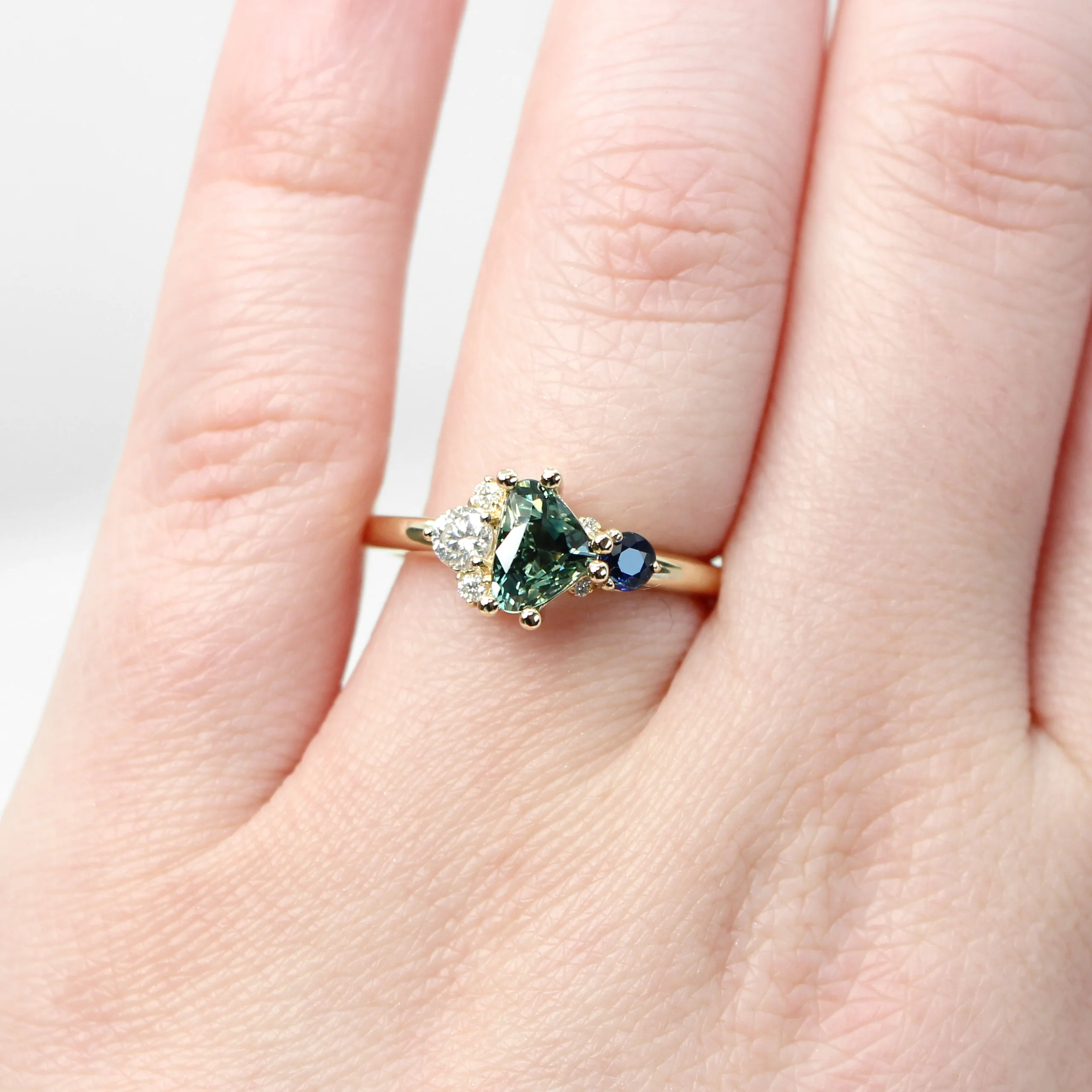 Project: Custom Serena Ring with a 1 Carat Teal Blue Trillion Sapphire and Asymmetrical Accent Diamonds in 14k - Image 4