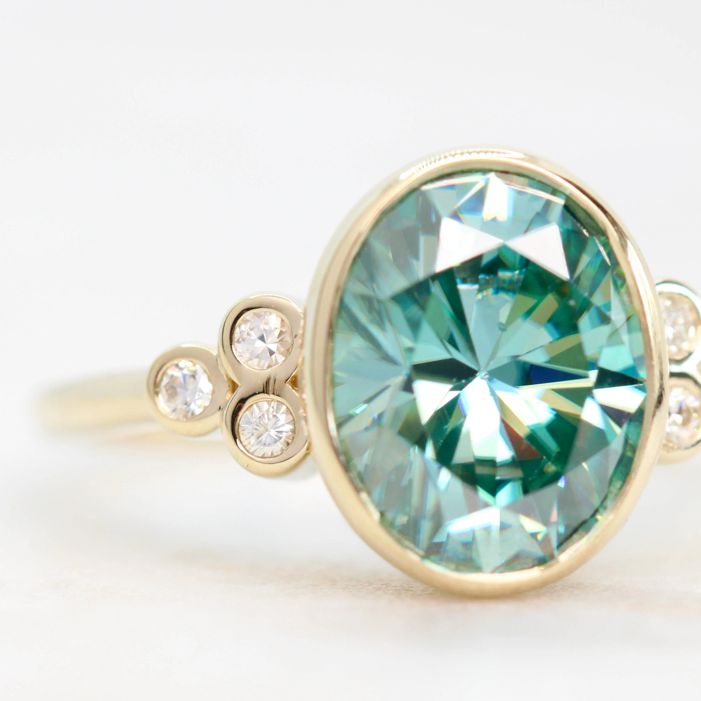 Project: Custom Sophia Ring with a 2.5 Carat Bezel Set Teal Oval Moissanite and Accent Diamonds in 14k - Image 4